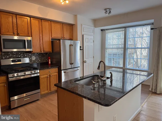 a kitchen with kitchen island granite countertop a stove sink and refrigerator