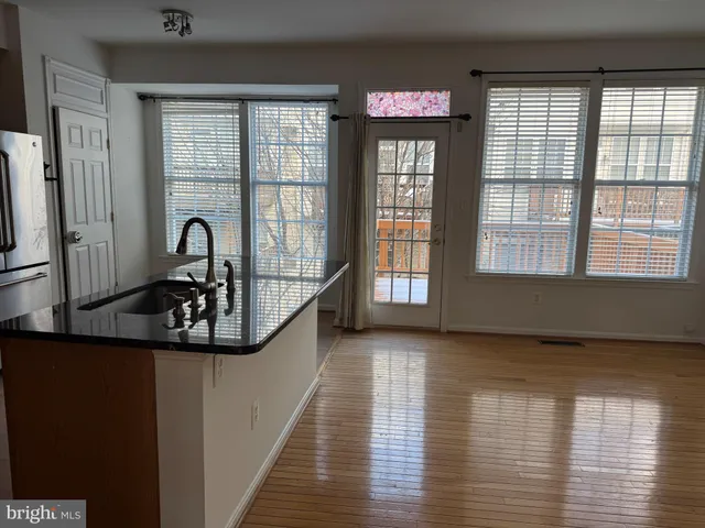 a view of a room that has a window and wooden floor