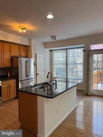 a kitchen with stainless steel appliances granite countertop a sink a stove and a refrigerator