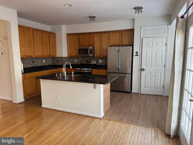 a kitchen with wooden cabinets and stainless steel appliances