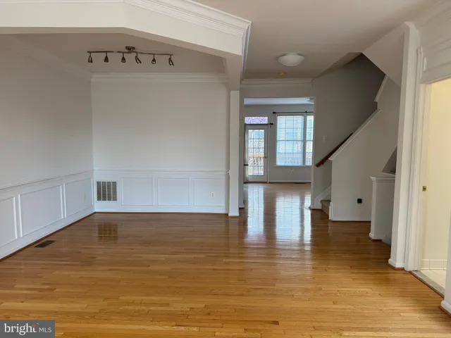 a view of empty room with wooden floor