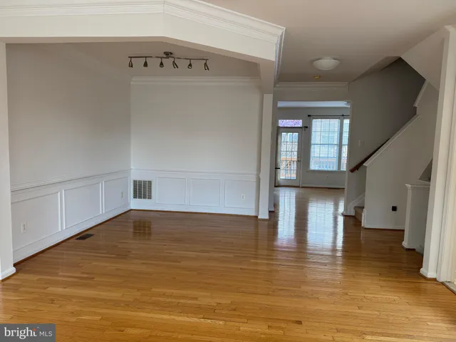 a view of empty room with wooden floor