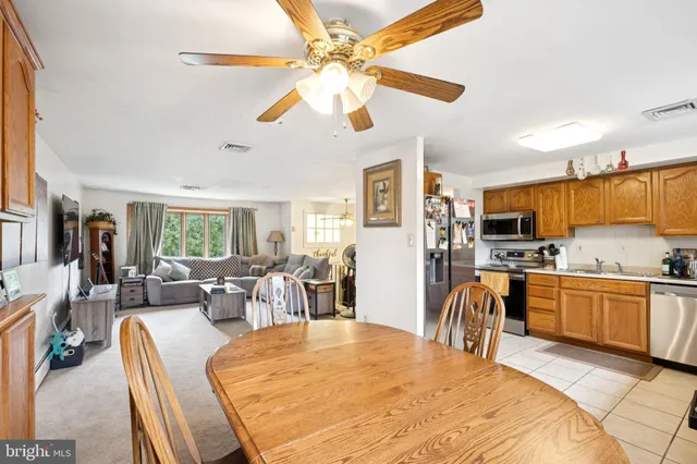 a large kitchen with kitchen island a stove a sink a dining table and chairs with wooden floor