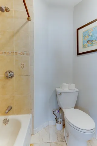 a white toilet sitting next to a bath tub