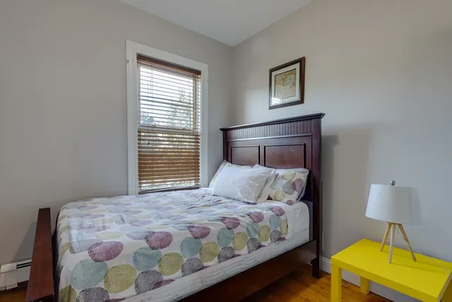 a bedroom with a bed and a lamp on dresser