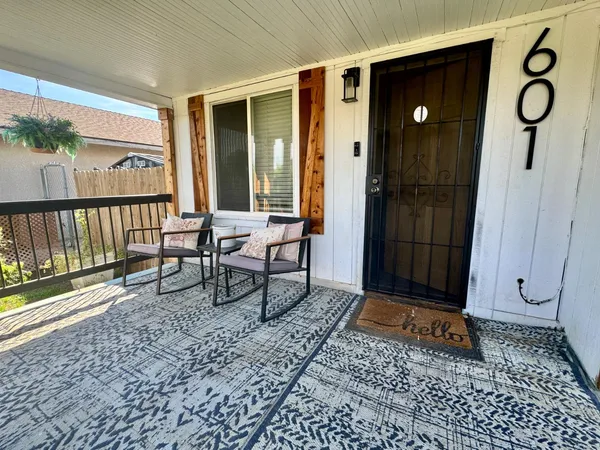 a view of a porch with a table and chairs