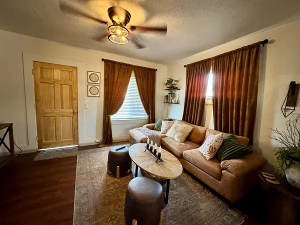 a living room with furniture and wooden floor