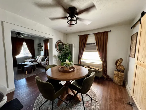 a dining room with wooden floor and a chandelier
