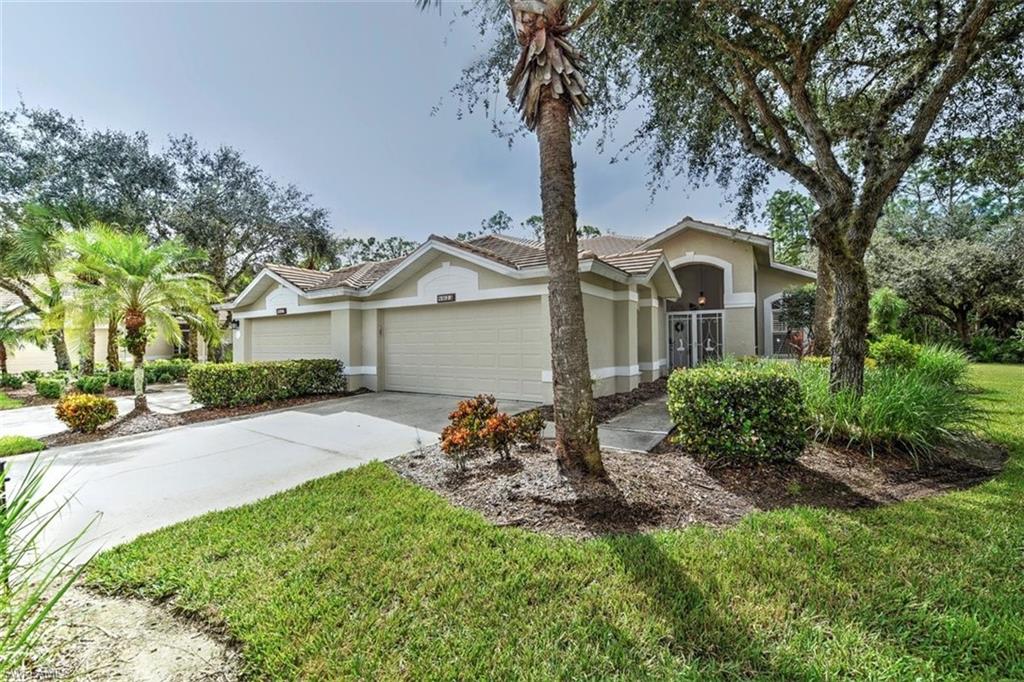 8023 Kilkenny Way, Unit G31 Naples, FL 34112 - Photo 1 of 2 a front view of a house with a garden and trees