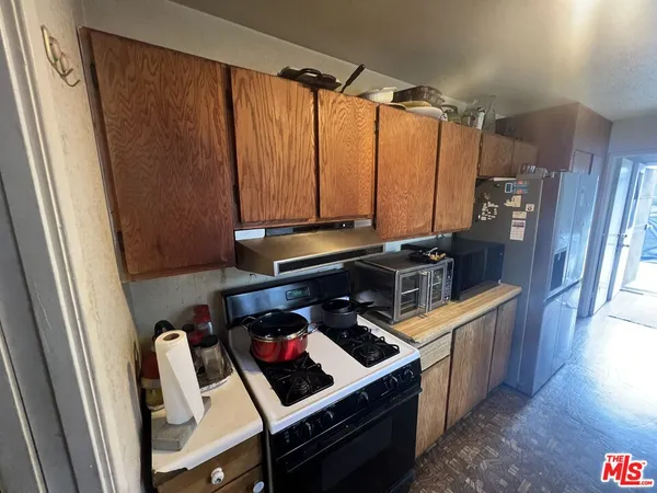 a kitchen with a stove a refrigerator and a window