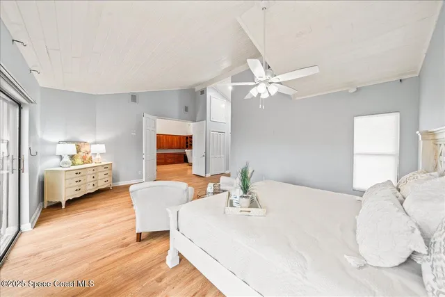 a spacious bedroom with a bed and a large window