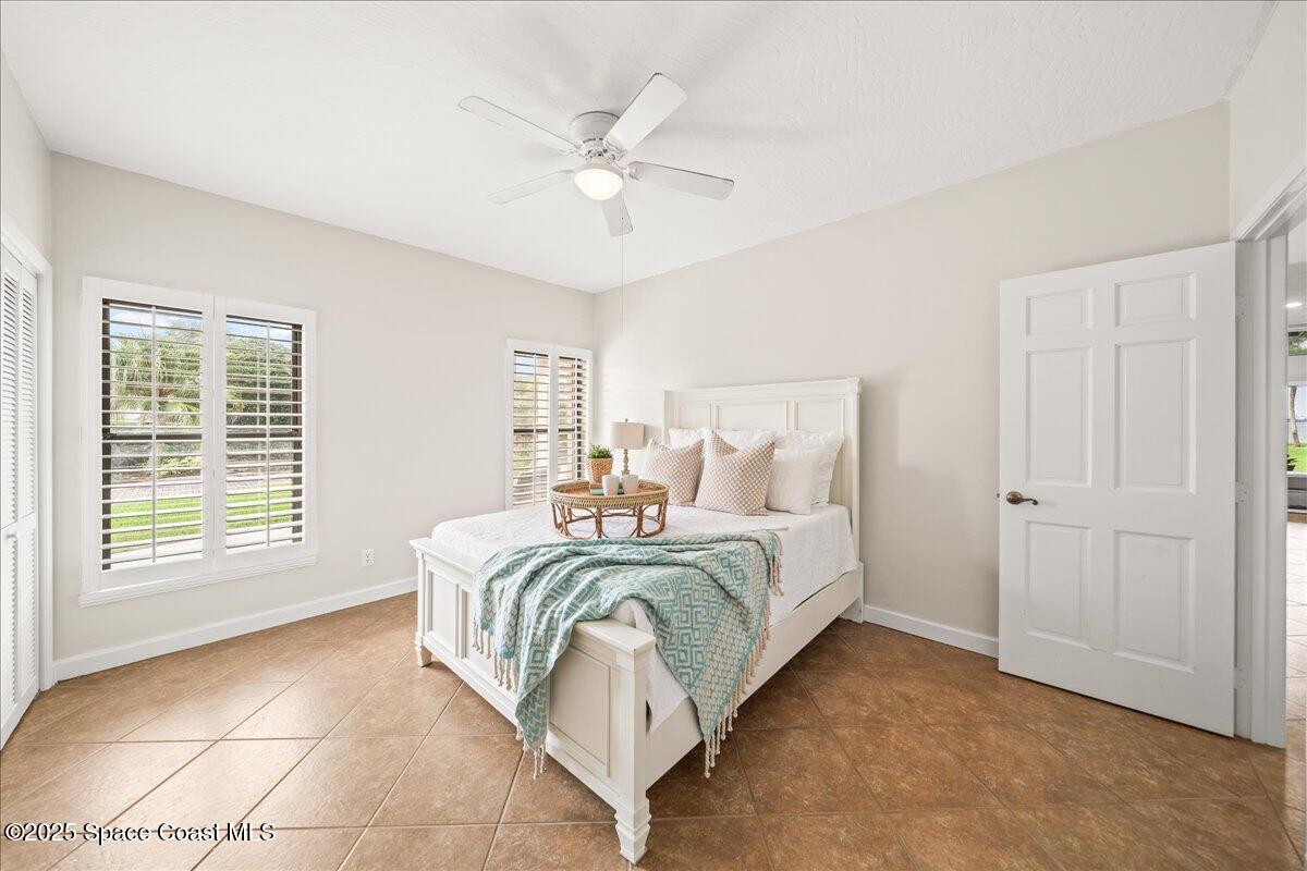 208 The Road, Unit C2 Melbourne Beach, FL 32951 - Photo 35 of 65 a spacious bedroom with a bed a closet and large window