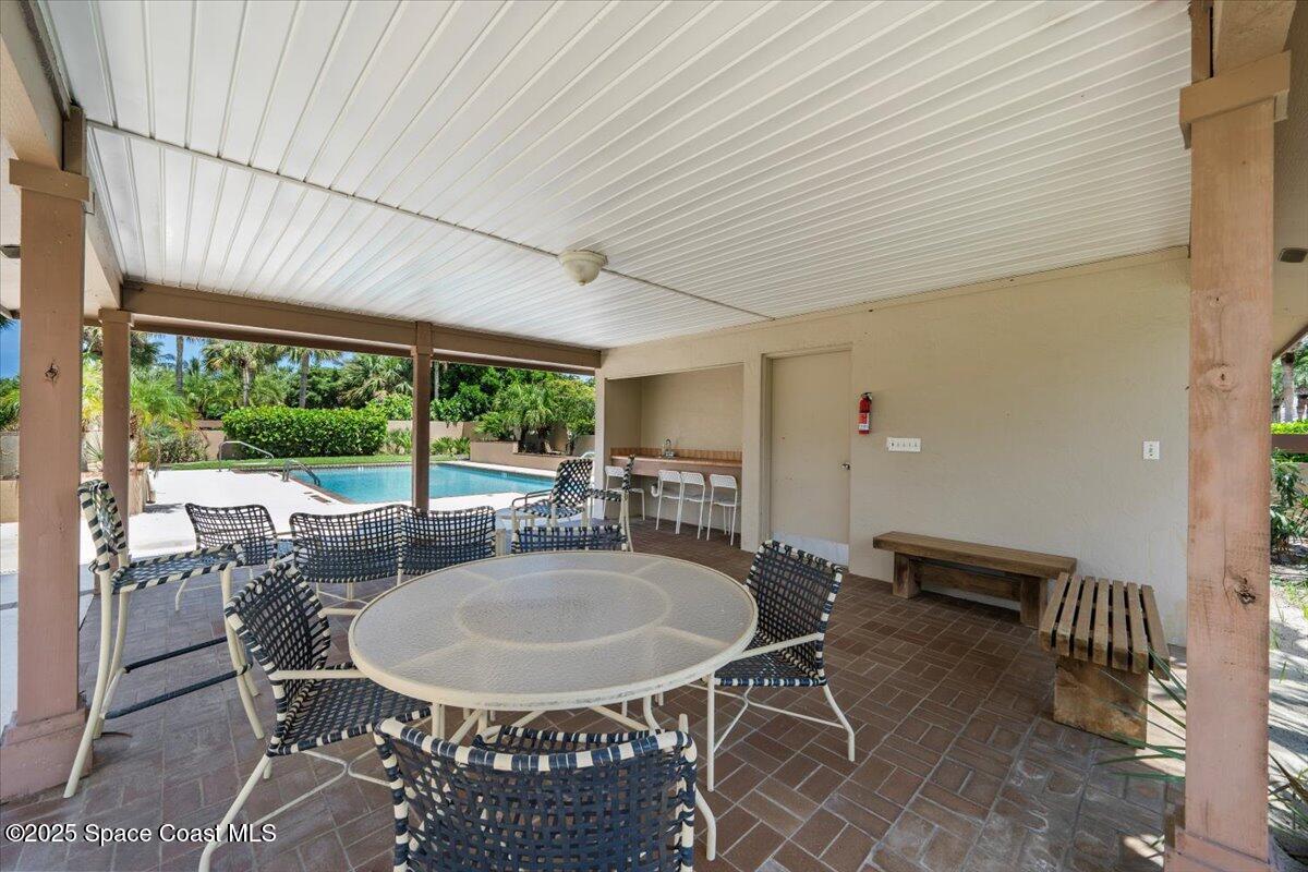 208 The Road, Unit C2 Melbourne Beach, FL 32951 - Photo 54 of 65 a dining room with furniture and a floor to ceiling window