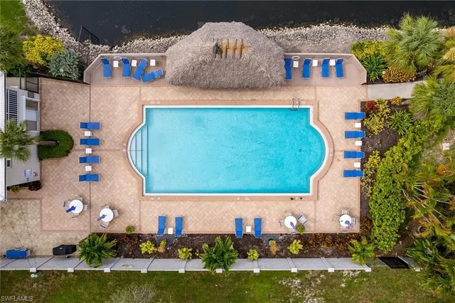 an aerial view of a house with swimming pool a yard and outdoor seating