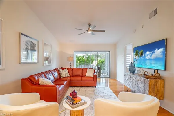 a living room with furniture a large window and a flat screen tv