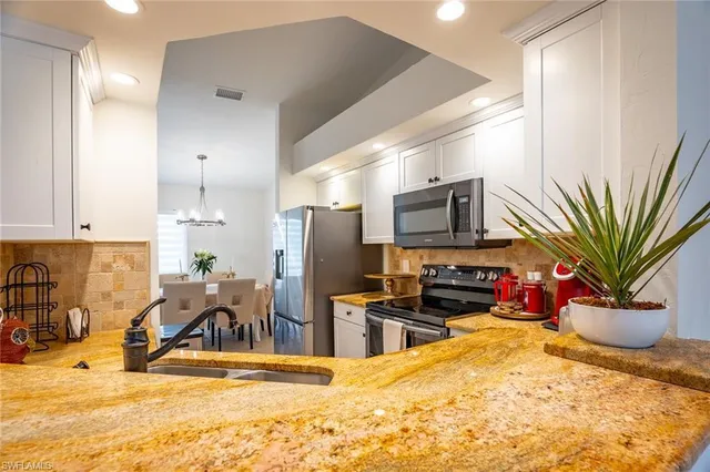 a view of a kitchen with refrigerator and a sink