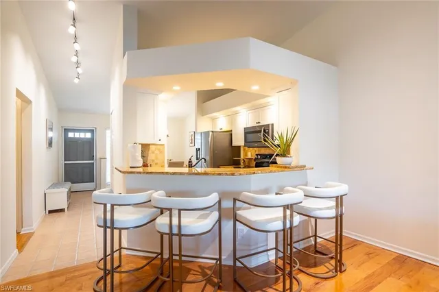 a dining hall with stainless steel appliances a dining table and chairs