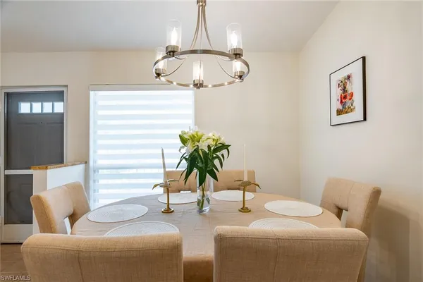 a living room with furniture a chandelier and a window