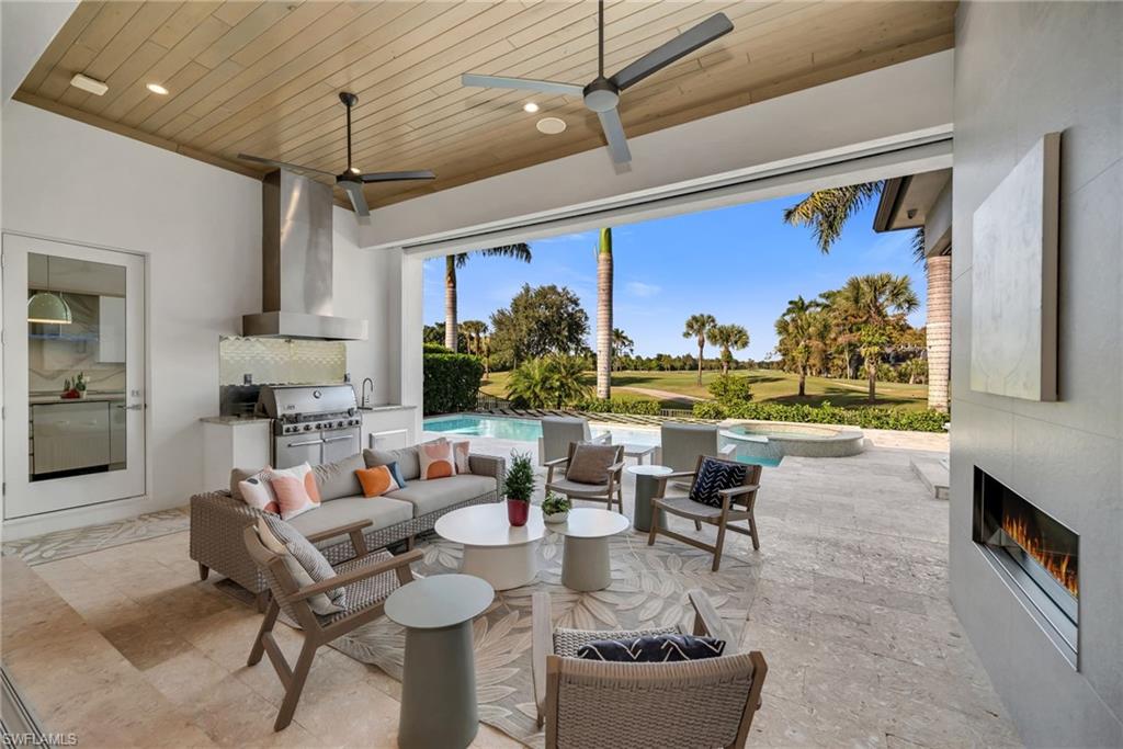 1671 Vinland Way Naples, FL 34105 - Photo 11 of 50 a living room with fireplace furniture and a large window