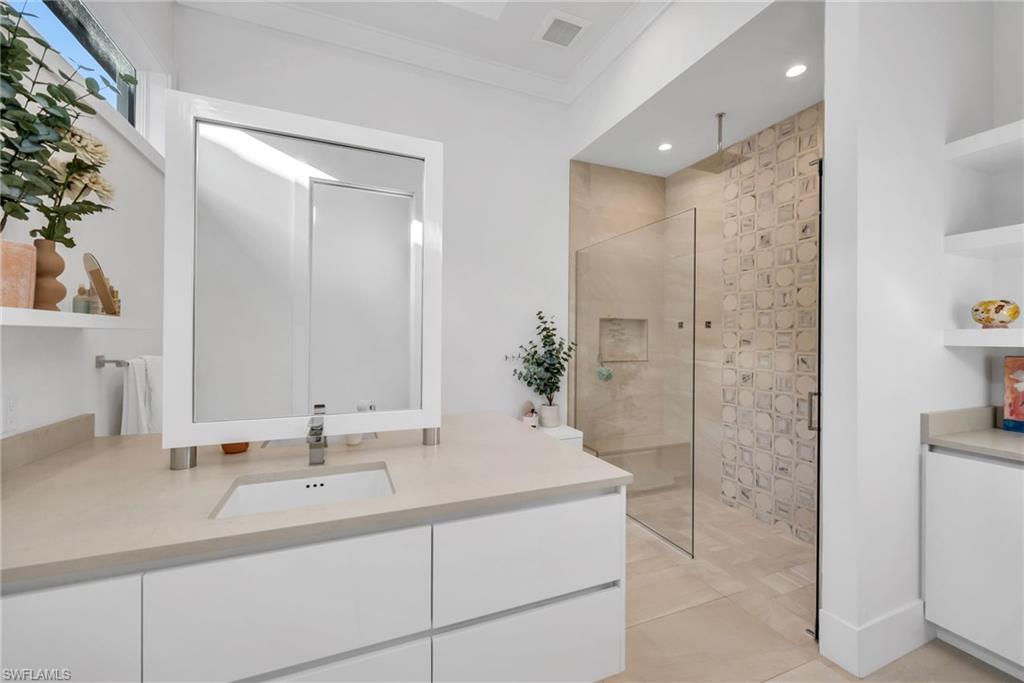 1671 Vinland Way Naples, FL 34105 - Photo 15 of 50 a bathroom with a double vanity sink mirror and shower
