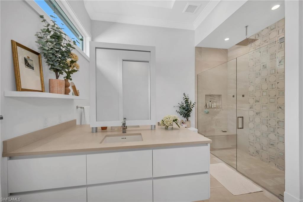 1671 Vinland Way Naples, FL 34105 - Photo 16 of 50 a bathroom with a sink and a mirror
