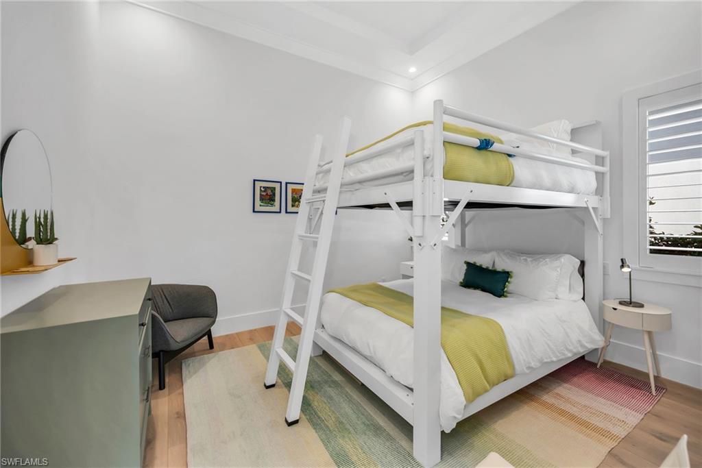 1671 Vinland Way Naples, FL 34105 - Photo 21 of 50 a bedroom with a bed and a chair