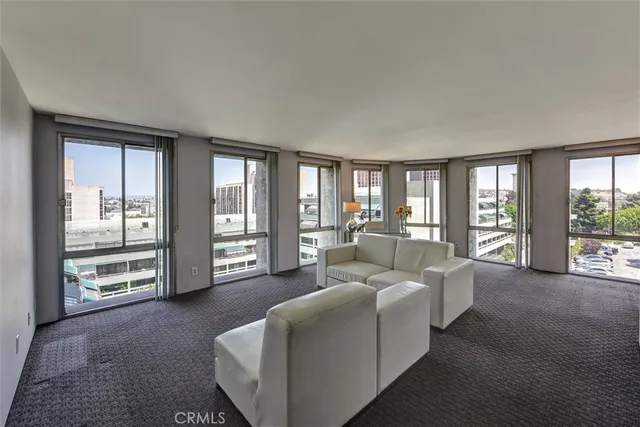 a living room with furniture and large windows