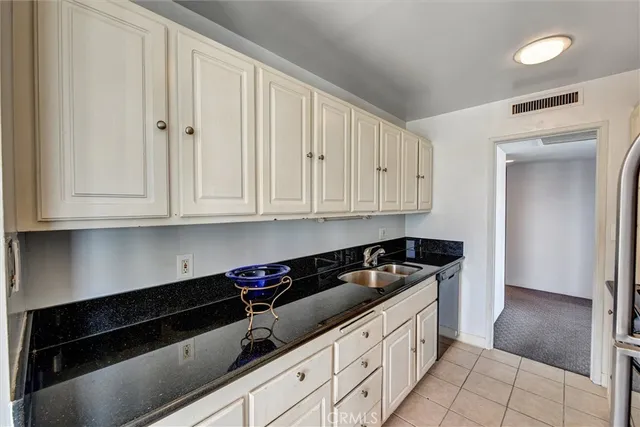 a kitchen with granite countertop white cabinets and black appliances