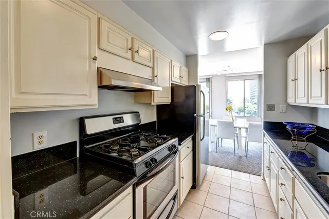 a kitchen with stainless steel appliances granite countertop a stove refrigerator and cabinets