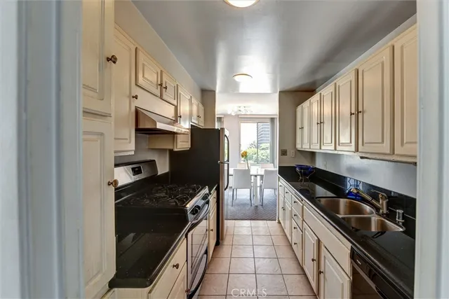 a kitchen with stainless steel appliances granite countertop a stove a sink and a refrigerator