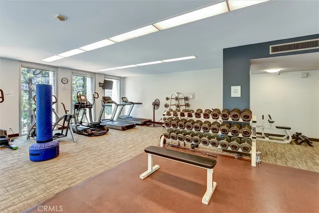a room with gym equipment and large mirror