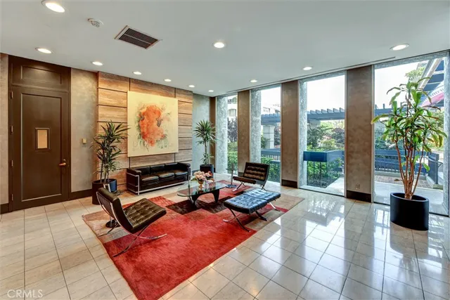 a living room with patio furniture and floor to ceiling window