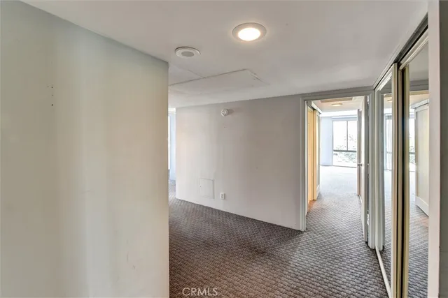 a view of hallway with a large window and wooden floor