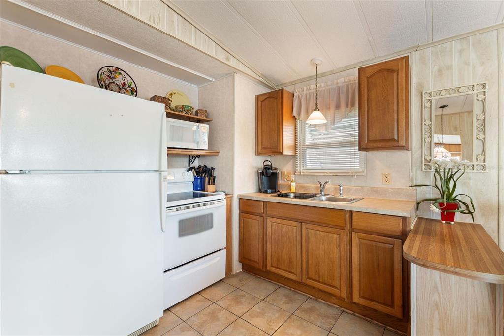 251 Patterson Road, Unit G9 Haines City, FL 33844 - Photo 13 of 40 a kitchen with a sink a refrigerator and cabinets