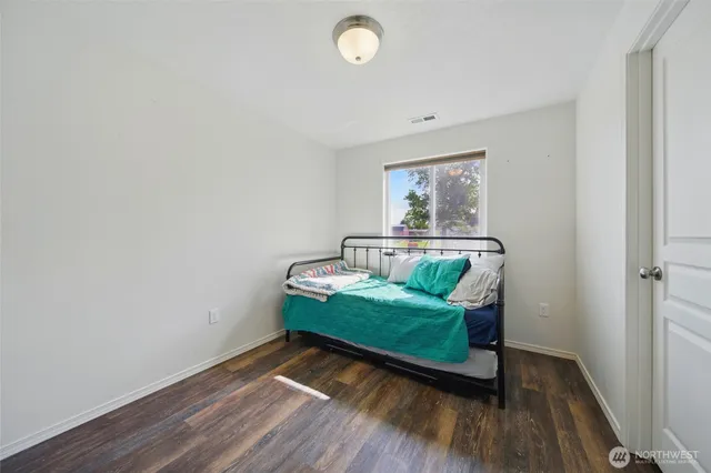 a bedroom with bed and painting on the wall