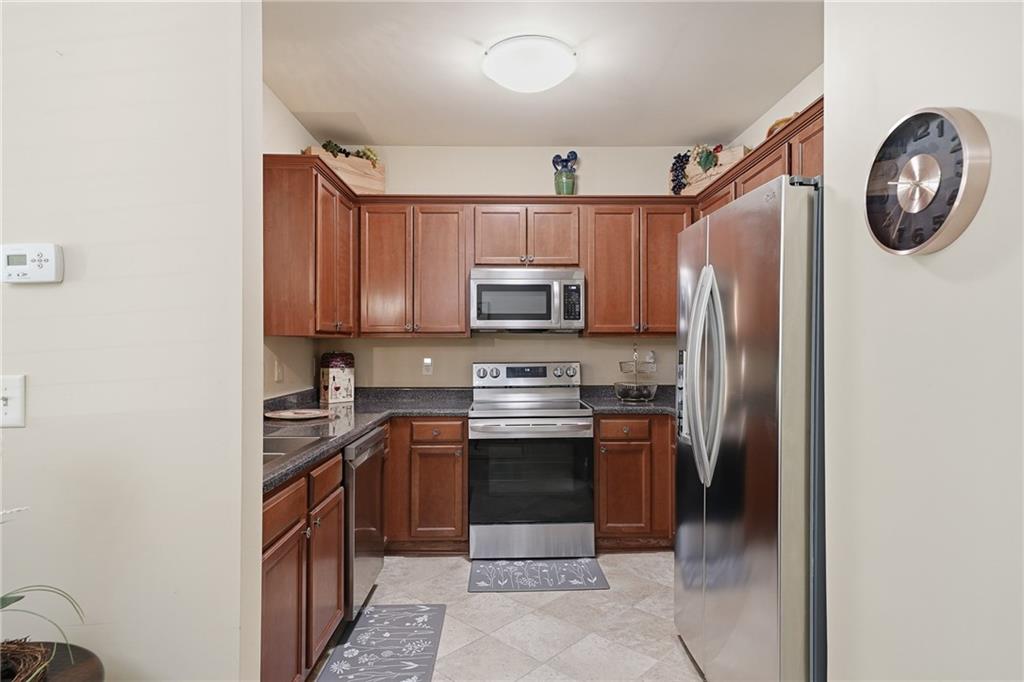 608 Myers Gate Road Ball Ground, GA 30107 - Photo 7 of 31 a kitchen with stainless steel appliances granite countertop a stove a refrigerator and a microwave