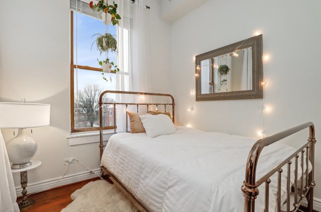 140 Ridge Avenue, Unit 2W Evanston, IL 60202 - Photo 25 of 36 a bedroom with a bed and with a painting on the wall