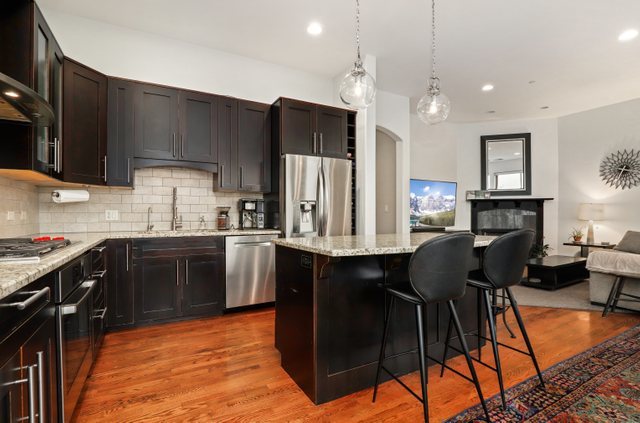 140 Ridge Avenue, Unit 2W Evanston, IL 60202 - Photo 6 of 36 a kitchen with stainless steel appliances granite countertop a stove top oven a sink dishwasher a dining table and chairs with wooden floor