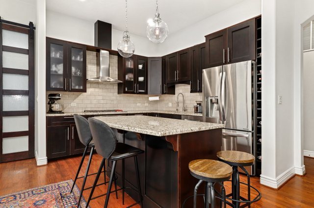 140 Ridge Avenue, Unit 2W Evanston, IL 60202 - Photo 8 of 36 a kitchen with stainless steel appliances granite countertop a table chairs stove and refrigerator