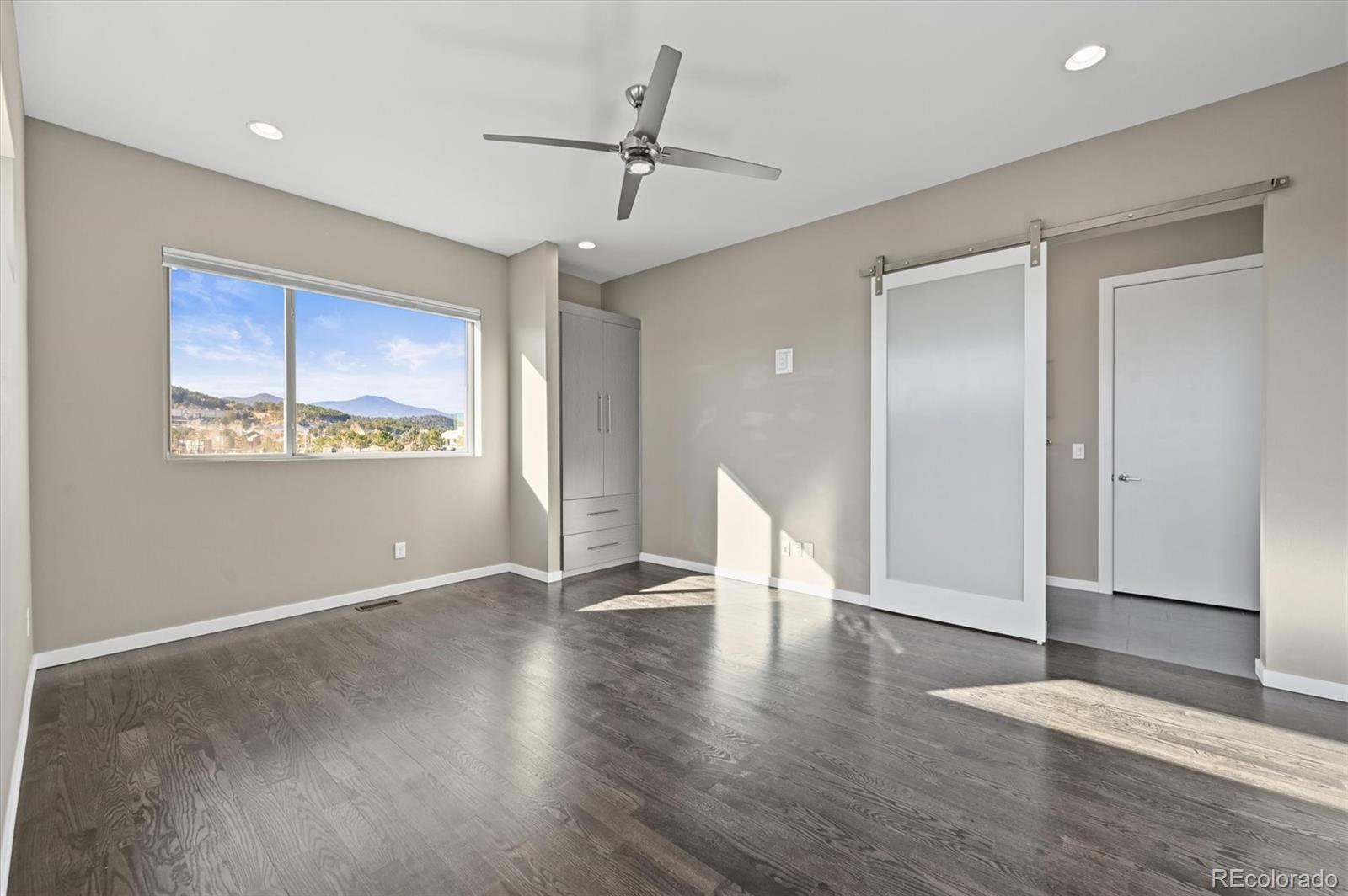 28424 Tepees Way Evergreen, CO 80439 - Photo 13 of 47 a view of an empty room with a window and wooden floor