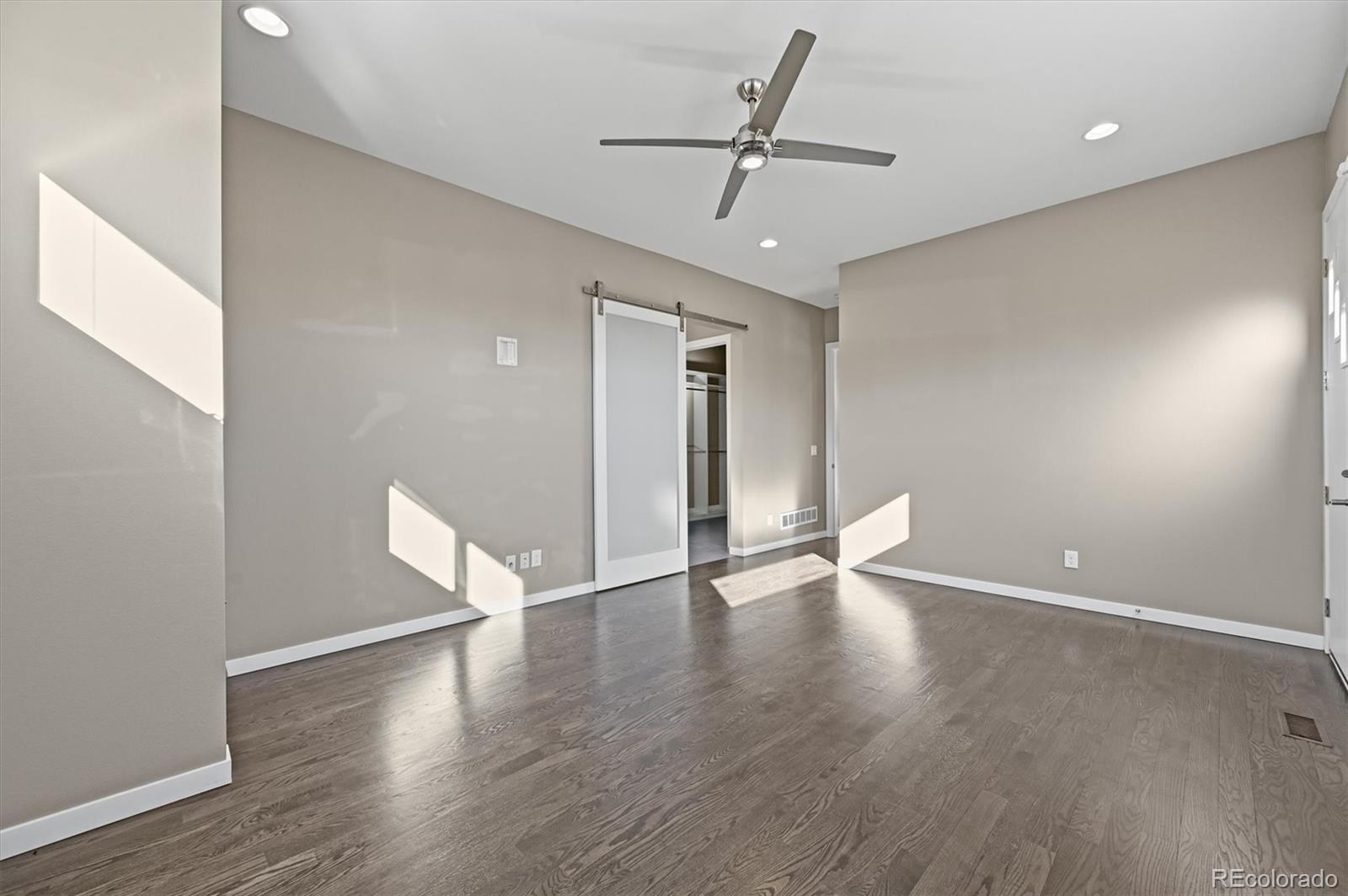28424 Tepees Way Evergreen, CO 80439 - Photo 16 of 47 an empty room with wooden floor and windows