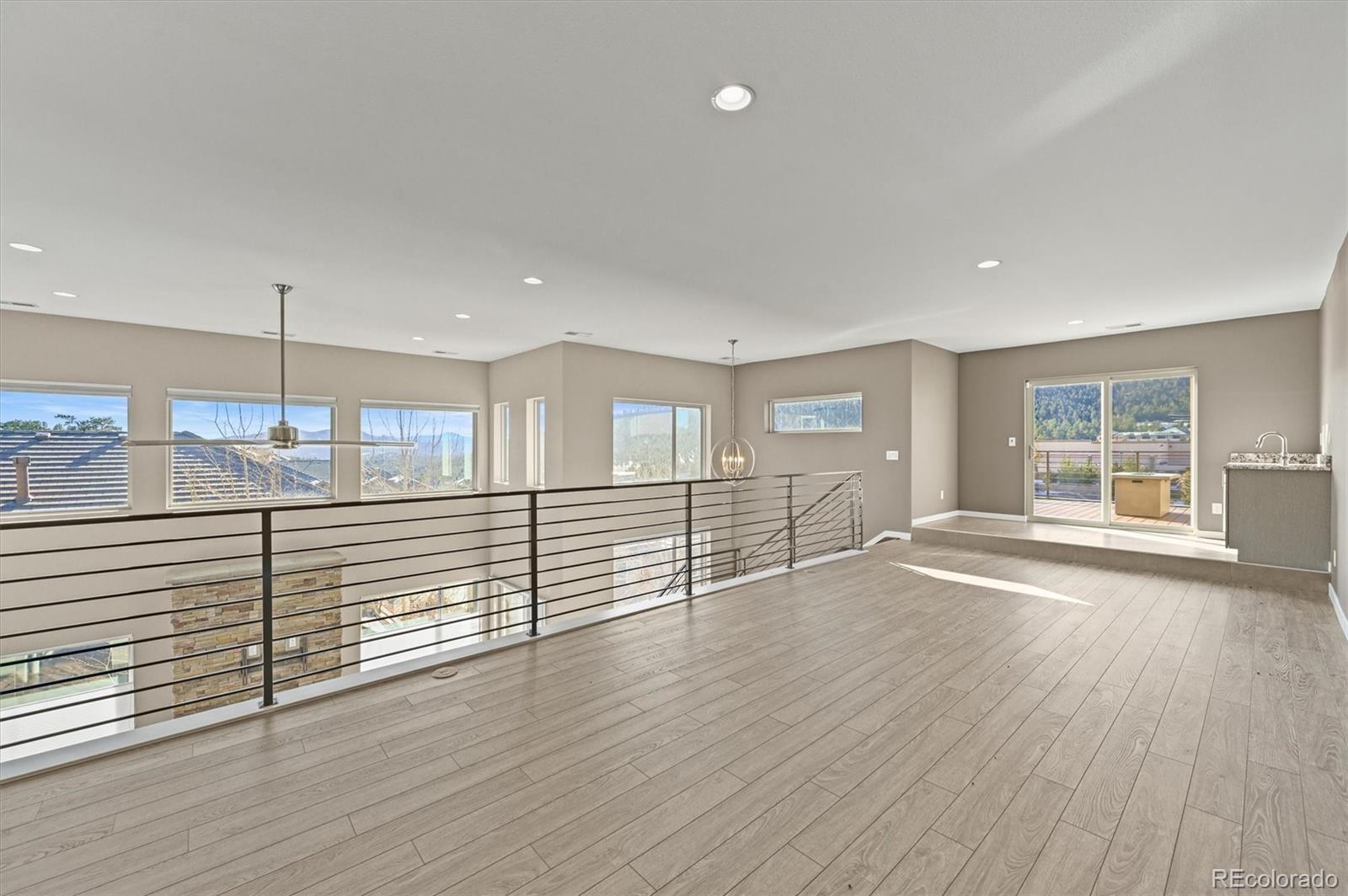 28424 Tepees Way Evergreen, CO 80439 - Photo 22 of 47 an empty room with wooden floor and windows