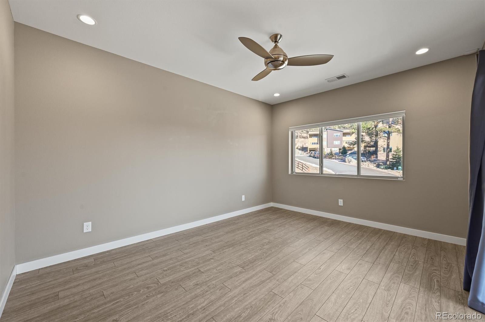 28424 Tepees Way Evergreen, CO 80439 - Photo 25 of 47 a view of an empty room with a window and wooden floor
