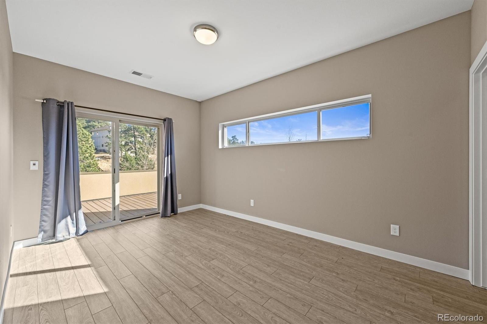 28424 Tepees Way Evergreen, CO 80439 - Photo 27 of 47 a view of an empty room with wooden floor and a window