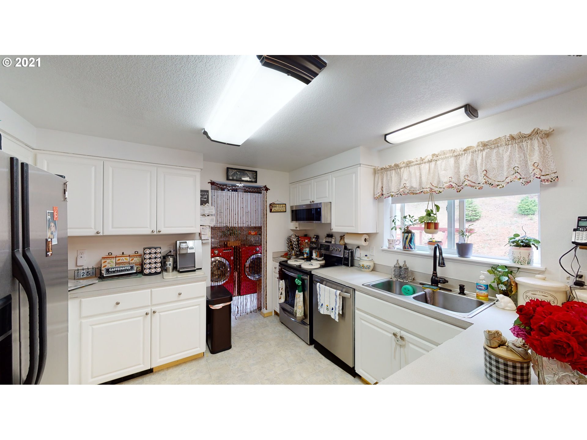1803 Byron Creek Road Winston, OR 97496 - Photo 11 of 32 a kitchen with a sink dishwasher white cabinets and refrigerator