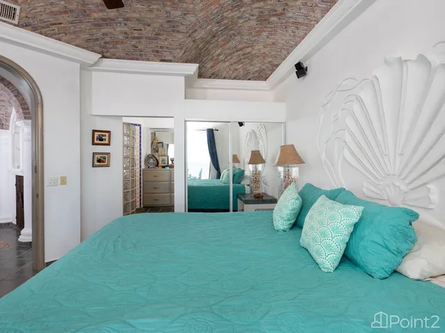 a living room with a bed and a flat tv screen on dresser