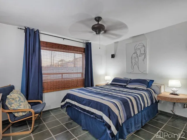 a bedroom with a bed a window and a chandelier