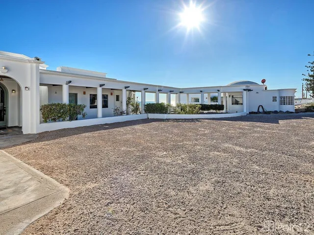 a front view of a house with swimming pool and furniture