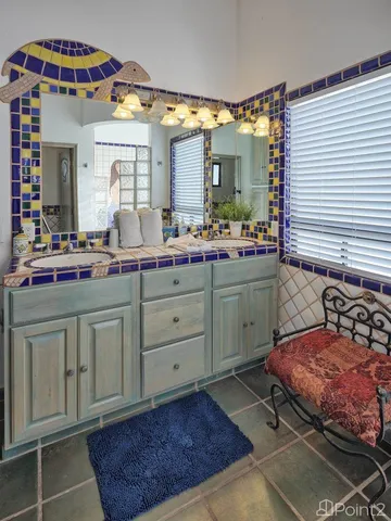 a bedroom with a bed and a large mirror next to a window