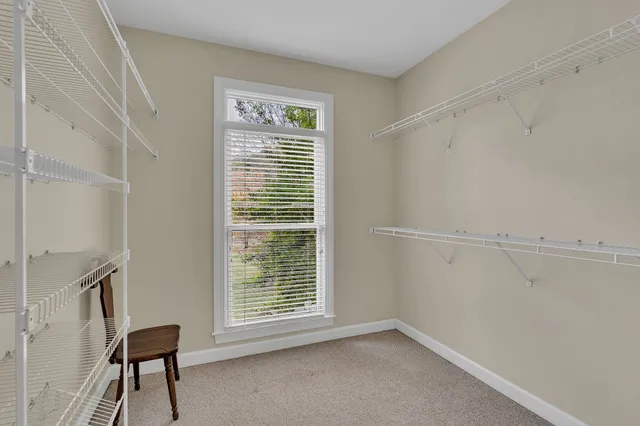 a view of an empty room with a ceiling fan and a window